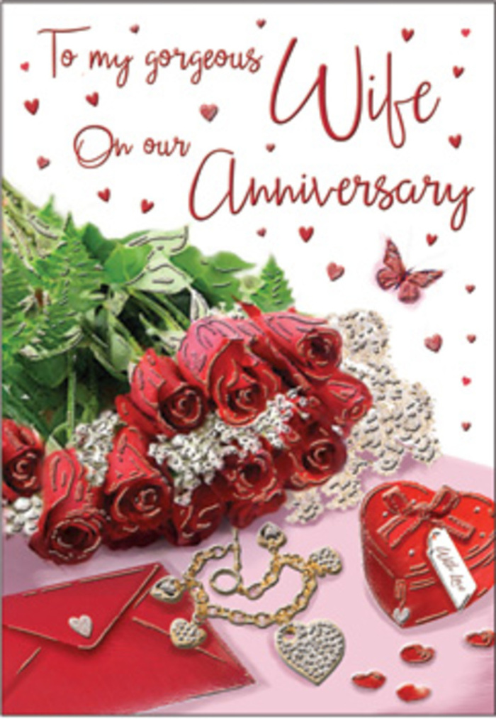 A richly romantic tableau unfolds on this anniversary card, as if arranged on a polished table in a quiet Isle of Dogs apartment, where city lights soften into a private celebration. At centre stage sits a classic bouquet of red roses, each bloom round and luxuriously full, wrapped with simple elegance and threaded with lush green foliage that adds depth and movement. The roses glow in deep ruby tones, evoking passion tempered by comfort, like a couple who has watched many sunsets along the Thames together. Nearby, delicate heart motifs and whisper-thin lace details catch the eye, resting beside a refined jewellery set whose metallic surfaces glimmer gently. A vivid red gift box adds a note of occasion, suggesting a treasured present saved for this special date. The textures in the scene invite touch: the imagined softness of velvet ribbon, the cool smoothness of gold, the silky slip of the card stock beneath the fingertips. Light washes over the composition in a warm, steady way, much like the calm ambience of Island Gardens at dusk, creating a mood that is unmistakably romantic. Everything, from the flowing, scripted anniversary message to the interplay of red, cream and green, is arranged with the steady hand of a skilled florist, turning a simple card into a visual embrace that honours all the memories a couple has built together in and around Isle of Dogs.