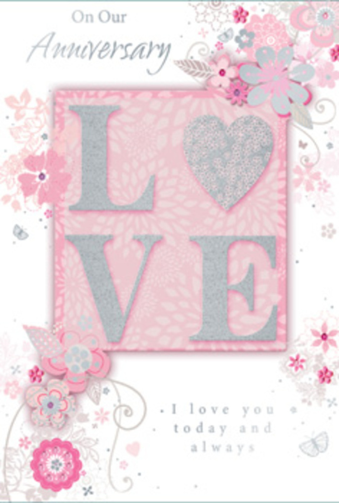 The image reveals an anniversary card that feels as tender and thoughtful as a hand-tied bouquet delivered to a riverside flat in Isle of Dogs. Dominating the centre is the word LOVE, each letter embossed so it stands proudly from the surface, the raised edges dusted with soft glitter. The glittering finish is subtle and refined, primarily in silvery white and gentle blush tones, catching the light without overwhelming the delicate artwork that surrounds it. This central motif sits on a slightly deeper blush-pink panel, creating a gentle contrast with the lighter pink background and giving the composition a sense of depth, much like layers of petals nestled within a romantic arrangement. Encircling the word are graceful sprays of illustrated flowers and trailing leaves. The blossoms, in shades of blush, ivory, and light grey, curl outward in loose, swirling lines reminiscent of the natural arc of stems shaped by an experienced florist. Fine detailing around the petals and foliage hints at soft shading and filigree accents, with occasional touches of silver that glint faintly, suggesting dewdrops on fresh blooms around Mudchute Park and Farm on an early spring morning. Tiny flourishes and loops fill the spaces between flowers, adding a sense of movement and gentle celebration. An elegant script message, expressing enduring love and happy anniversary wishes, is placed thoughtfully within the design, the lettering slender and graceful like winding stems. The overall impression is one of calm romance and quiet joy, echoing the feeling of receiving a beautifully scented anniversary bouquet delivered across the Isle of Dogs and nearby Canary Wharf.